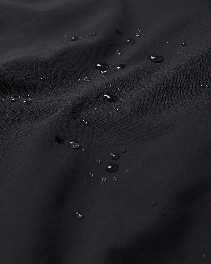 A close up detailed shot of water beading on black material, indicating the water repellency of the item. | The Black Ones | Performance-Wear Brand | Lightweight Performance-Wear